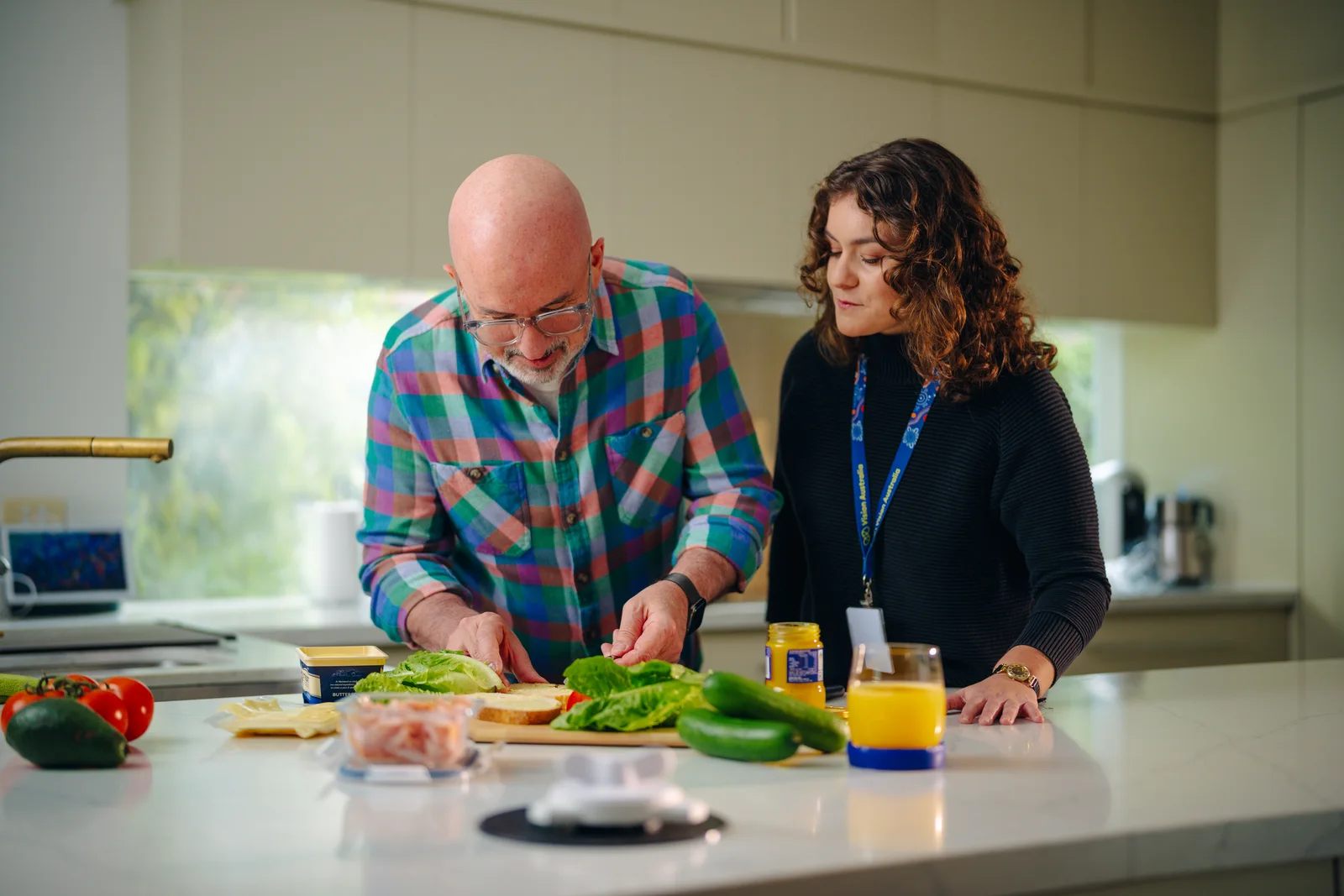 A Vision Australia team member supporting a client with meal preparation.